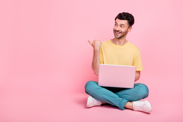 Photo of cheerful man sit interested look thumb direct empty space offer sale shop ph sumsung isolated on pink color background