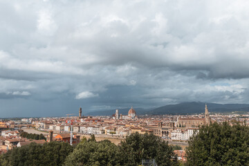 Fototapeta na wymiar Amazing old town with vintage houses and cathedrals on a cloudy day with clouds in Florence, Italy