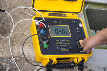 Technician is using a tester to measure electrical ground. Earth resistance tester. - obrazy, fototapety, plakaty