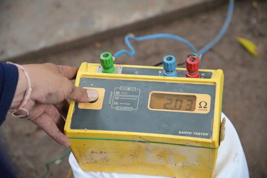 Technician is using a tester to measure electrical ground. Earth resistance tester.