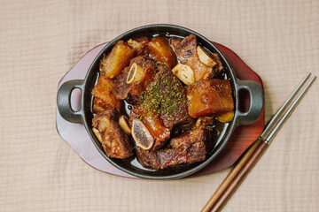 galbijjim, Korean Braised Short Ribs : Beef short ribs, trimmed of fat, seasoned in sweet soy sauce, and braised until tender with carrots, chestnuts, ginko nuts, and other vegetables.