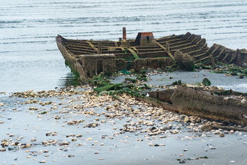 remains of a wrecked ship on a foggy seashore