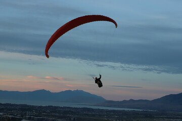 Person paragliding in between beautiful mountains