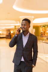 Portrait of handsome black businessman using mobile phone