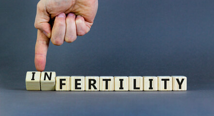 Fertility or infertility symbol. Concept words Fertility or Infertility on wooden cubes. Doctor hand. Beautiful grey table grey background. Medical fertility or infertility concept. Copy space.