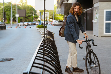 Fototapeta na wymiar Ginger european man walking with bicycle on city street