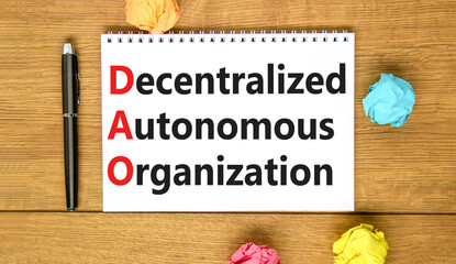 DAO decentralized autonomous organization symbol. Concept words DAO decentralized autonomous organization on white note on a beautiful wooden background. Business and DAO concept. Copy space.