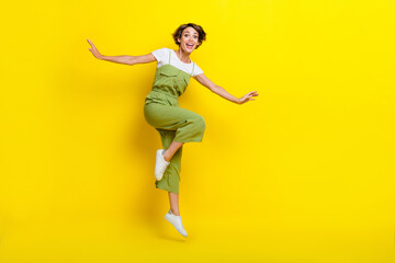 Full length photo of attractive girl youngster summertime vacation jumping celebrate black friday season carefree isolated on yellow color background