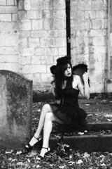 Woman dress up as a sexy fallen angel in a cemetery, Halloween
