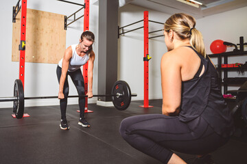 Nice Personal trainer helping woman in gym