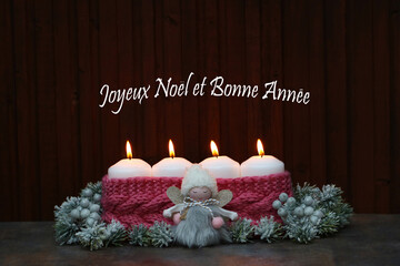 Quatre bougies allumées avec le texte Joyeux Noël et Bonne Année.