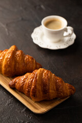 Croissants and coffee on dark background