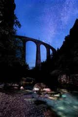Photo sur Plexiglas Viaduc de Landwasser Tir vertical du viaduc de Landwasser sous les étoiles magiques en Suisse