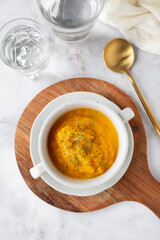 Homemade pumpkin cream in a white bowl. Vegetarian and vegan food ready to eat. Delicious vegetable cream