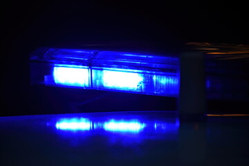 Police car with blue light on the street at night, selective focus
