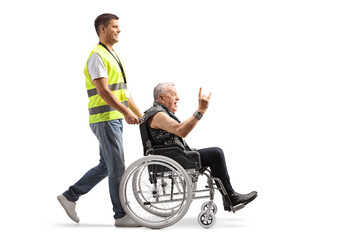 Full length profile shot of a community worker pushing a punk in a wheelchair