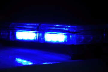 Police car with blue light on the street at night, selective focus