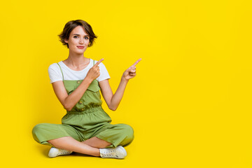 Fototapeta na wymiar Full length photo of pretty young lady point empty space useful tips promo dressed stylish khaki outfit isolated on yellow color background
