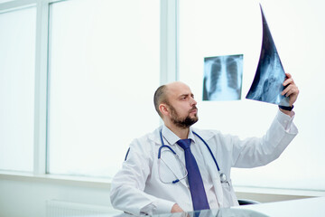 doctor is carefully looking at the X-ray.