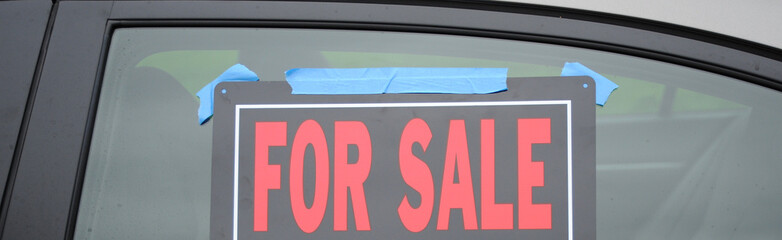 Car for sale sign on a car window.