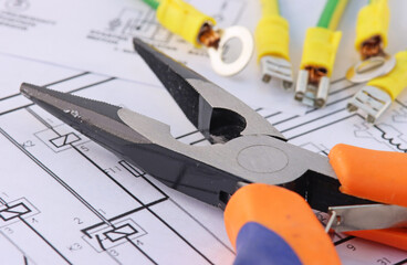 Tools for electrical installation and copper wires in colored insulation on the electrical diagram.Soft focus.