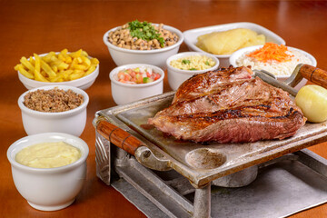 Barbecue steak roasted on the grill, served with traditional Brazilian side dishes. Churrasco.