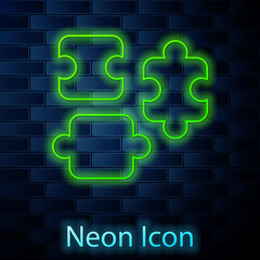 Glowing neon line Puzzle pieces toy icon isolated on brick wall background. Vector
