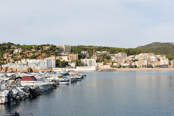 Fototapeta na wymiar Marina with small boats moored at the quay in Sant Feliu de Gixols, Catalonia, Spain