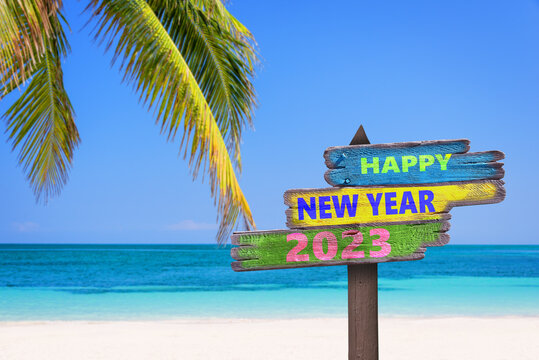 Hapy new year 2023 written on direction signs, tropical beach background, travel and tourism greeting card