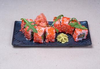 Close-up of fresh rolls with masago caviar, wasabi and pickled ginger. Delicious sushi in Japanese restaurant. Asian cuisine.