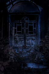 Porch of an old haunted house at night, low key. Door to an worn-down abandoned house in dark, creepy and spooky, vertical.