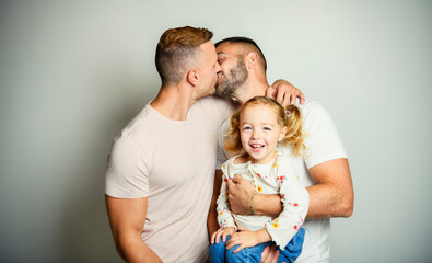 Two man couple with adopted child girl on white background