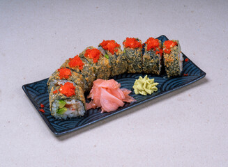 Close-up of rolls baked in tempura with red masago caviar on a beautiful rectangular plate. Japanese restaurant food. Asian cuisine.