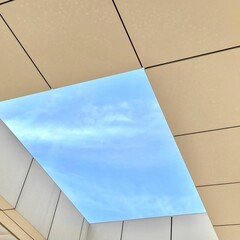 Low angle shot of a skylight window in a ceiling with a view of a blue sky