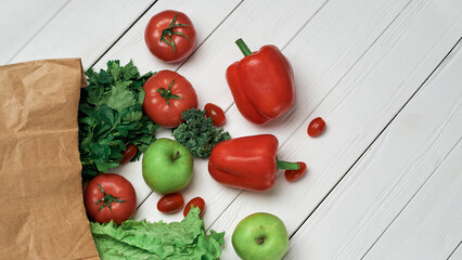 bag of fresh vegetables on a light wooden background .