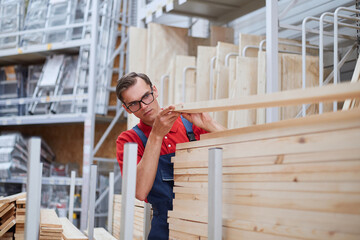 store manager selecting laminate flooring in the store's warehouse.