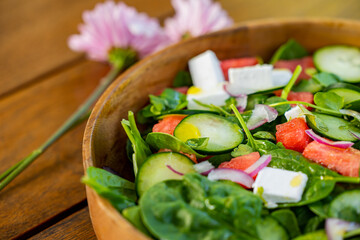 healthy green mix salad in bowl with spinach, tomato, oil and cucumber