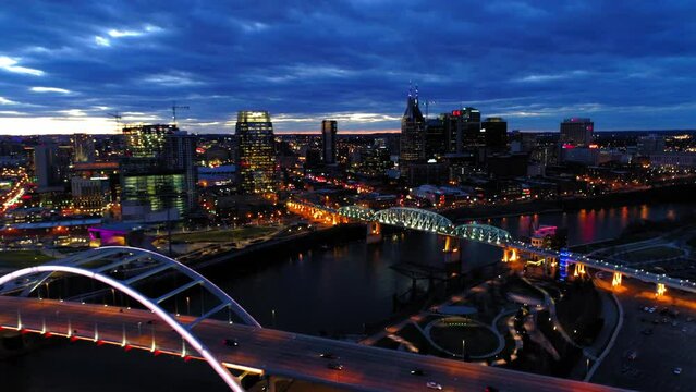 Aerial Forward Shot Of Illuminated Famous Bridges Over Cumberland River By Sparkling Modern City - Nashville, Tennessee