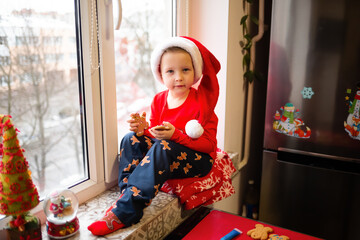 December 25, 2021 - Vinnytsia, Ukraine. A little boy has put on a Santa hat and is sitting at home...
