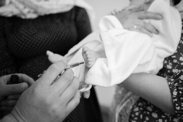 Grainy black and white photo of a baby being baptized in an Orthodox church