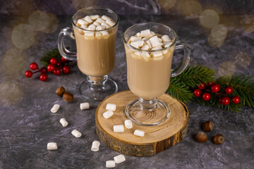 Christmas drink, cocoa with marshmallows on a dark concrete background with garland lights. A concept for holiday recipes and a winter menu. Festive mood new year, copy space for text