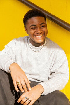 A portrait of a black trans masculine person smiling.