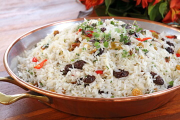 Christmas rice with raisins, pieces of tomatoes and herbs