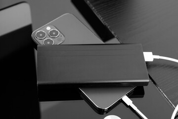 powerbank charges smartphone isolated on black background