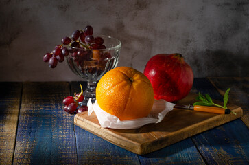 Orange Granatapfel und Trauben als Stillleben