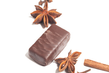 gourmet chocolate bonbons with anise and cinnamon sticks isolated on white background