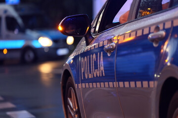 Akcja nocna  alarmowa policji - Sygnalizator błyskowy niebieski na dachu radiowozu policji polskiej w nocy. Światła policyjne. © FotoDax
