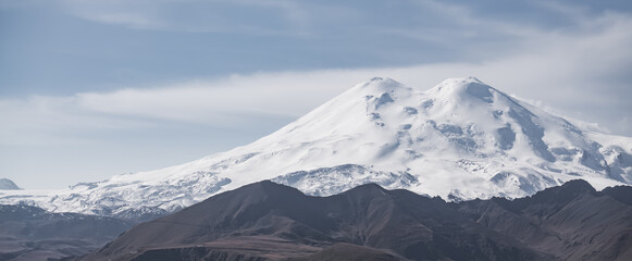 Panoramic mountain landscape of Mount Elbrus with snow and glaciers in cloudy weather, monochrome landscape panorama