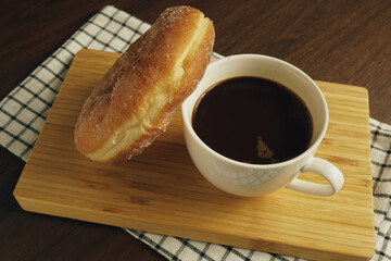 Freshly made donuts on the breakfast table with black coffee - 541787792