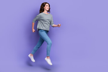 Full length photo of joyful optimistic lady wear stylish clothes run empty space reach dream aim goal isolated on purple color background